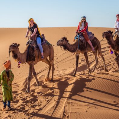 Gente montando en camello en la excursión de 7 días por Marruecos desde Casablanca