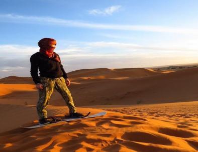 Sandboarding in Merzouga desert, Morocco.