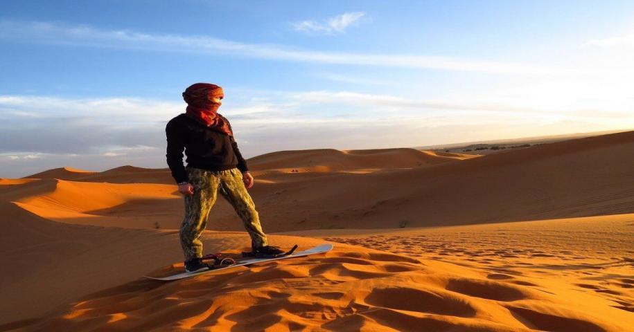 Sandboarding in Merzouga desert, Morocco.