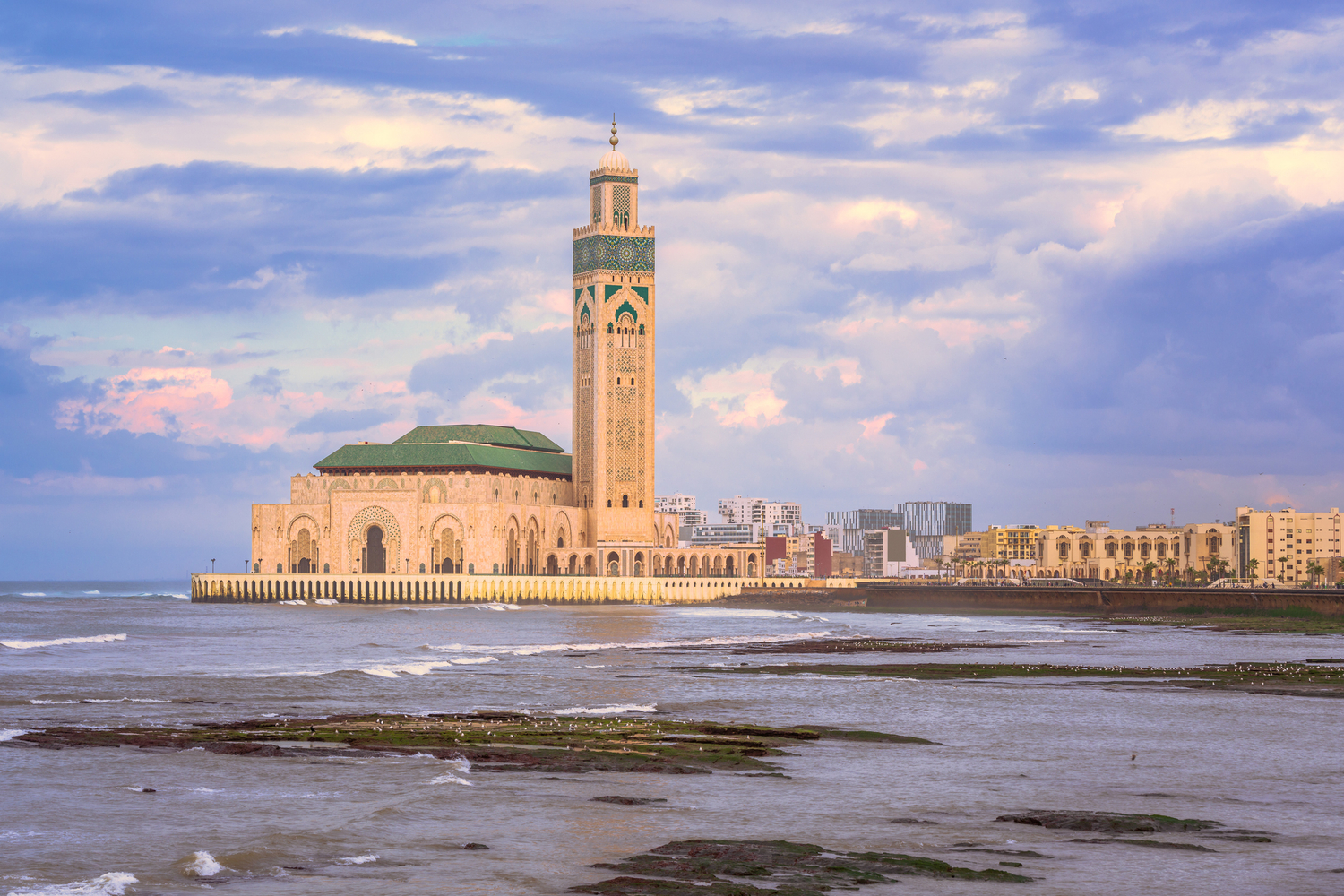Qué hacer en Casablanca – Mezquita Hassan II con alto minarete junto al Océano Atlántico bajo un cielo azul
