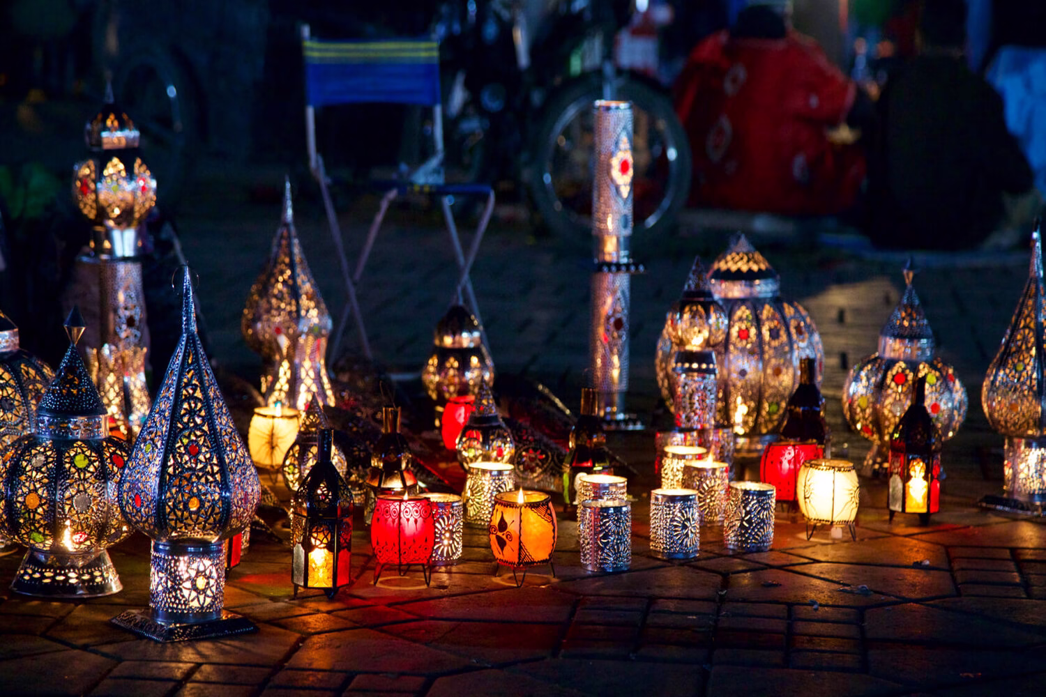 Faroles marroquíes tradicionales brillando por la noche en la plaza Jemaa el-Fna de Marrakech, creando un cálido ambiente festivo durante las celebraciones de Navidad y Nochevieja en Marruecos.
