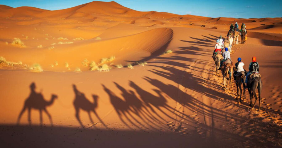 Tourists riding camels in the Merzouga desert during Christmas and new year's eve in Morocco.