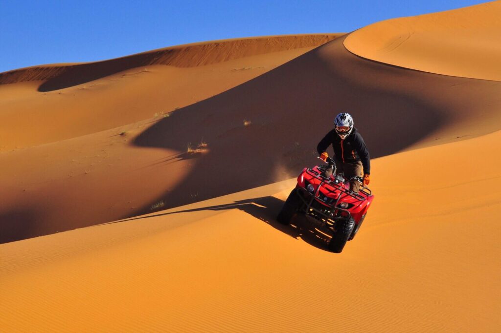 A tourist driving a quad in Merzouga dunes during Christmas time.