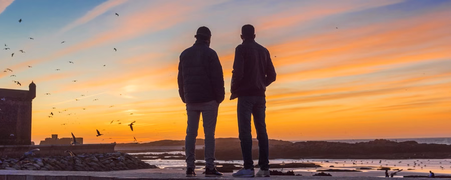 Dos hombres contemplando la vista en el puerto de Essaouira.