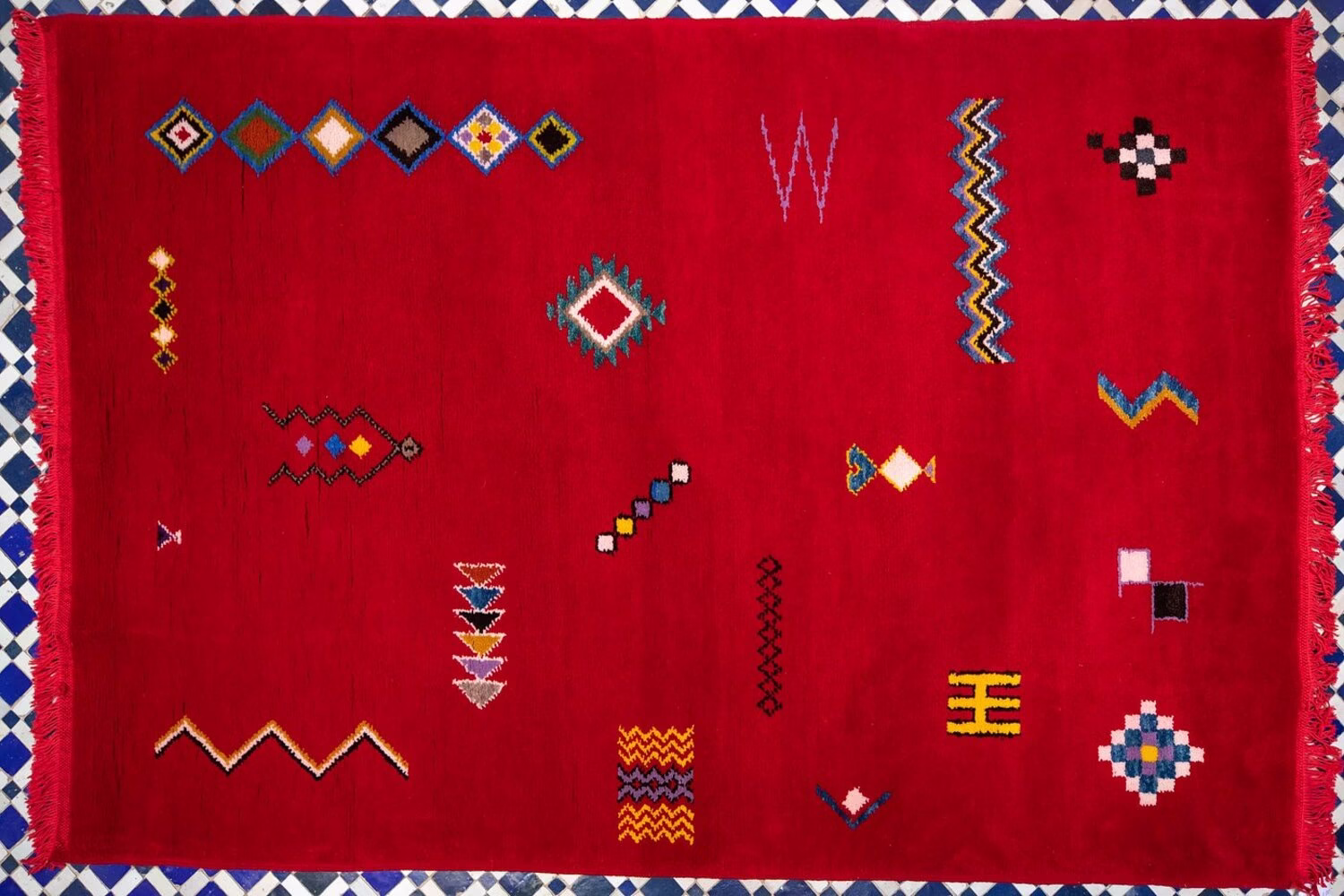 Alfombra bereber marroquí roja con símbolos geométricos minimalistas, que muestra la artesanía tradicional de las alfombras y tapetes marroquíes.