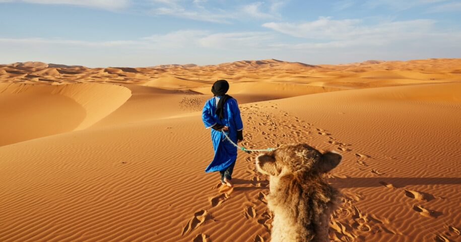 A camel driver in the Merzouga desert: one of the ways to travel around Morocco.