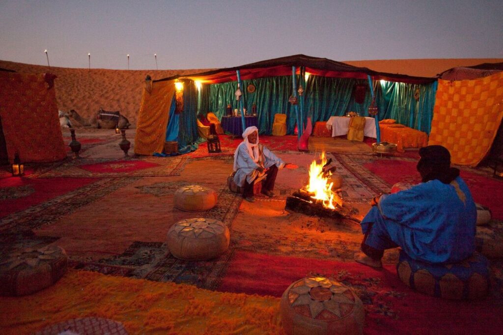 Two desert man sitting fire for people from Singapore in Morocco.