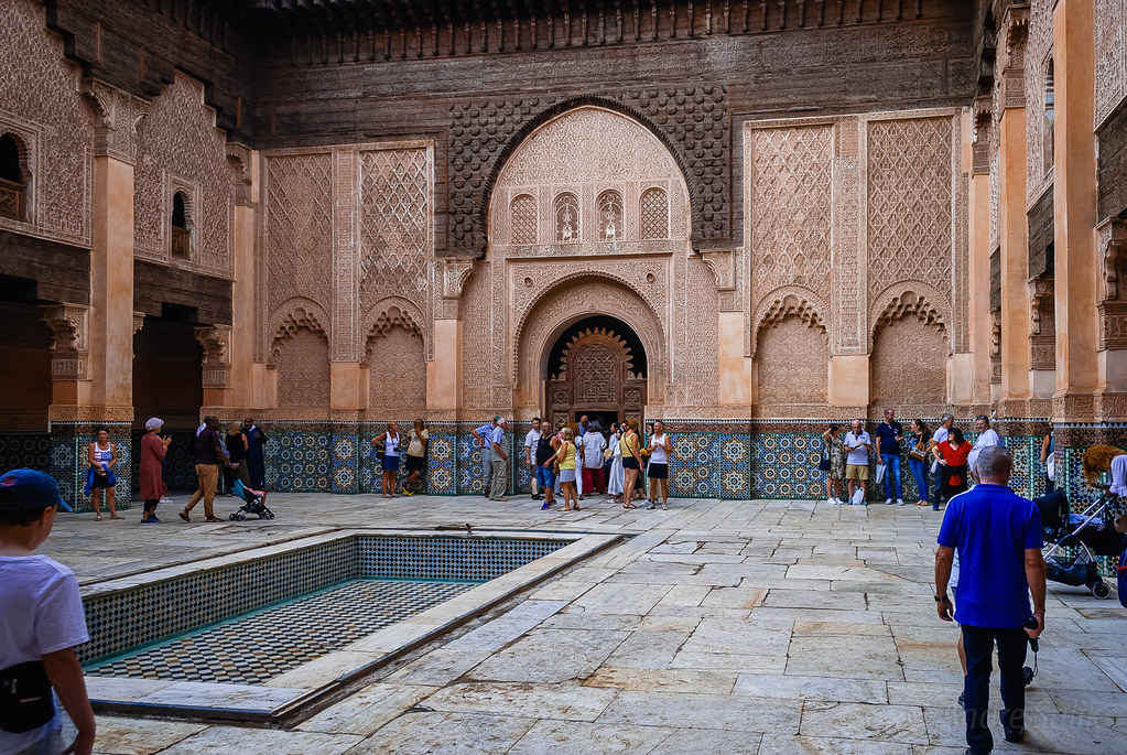 A Moroccan Madrasa from inside with tourists wandering around.
